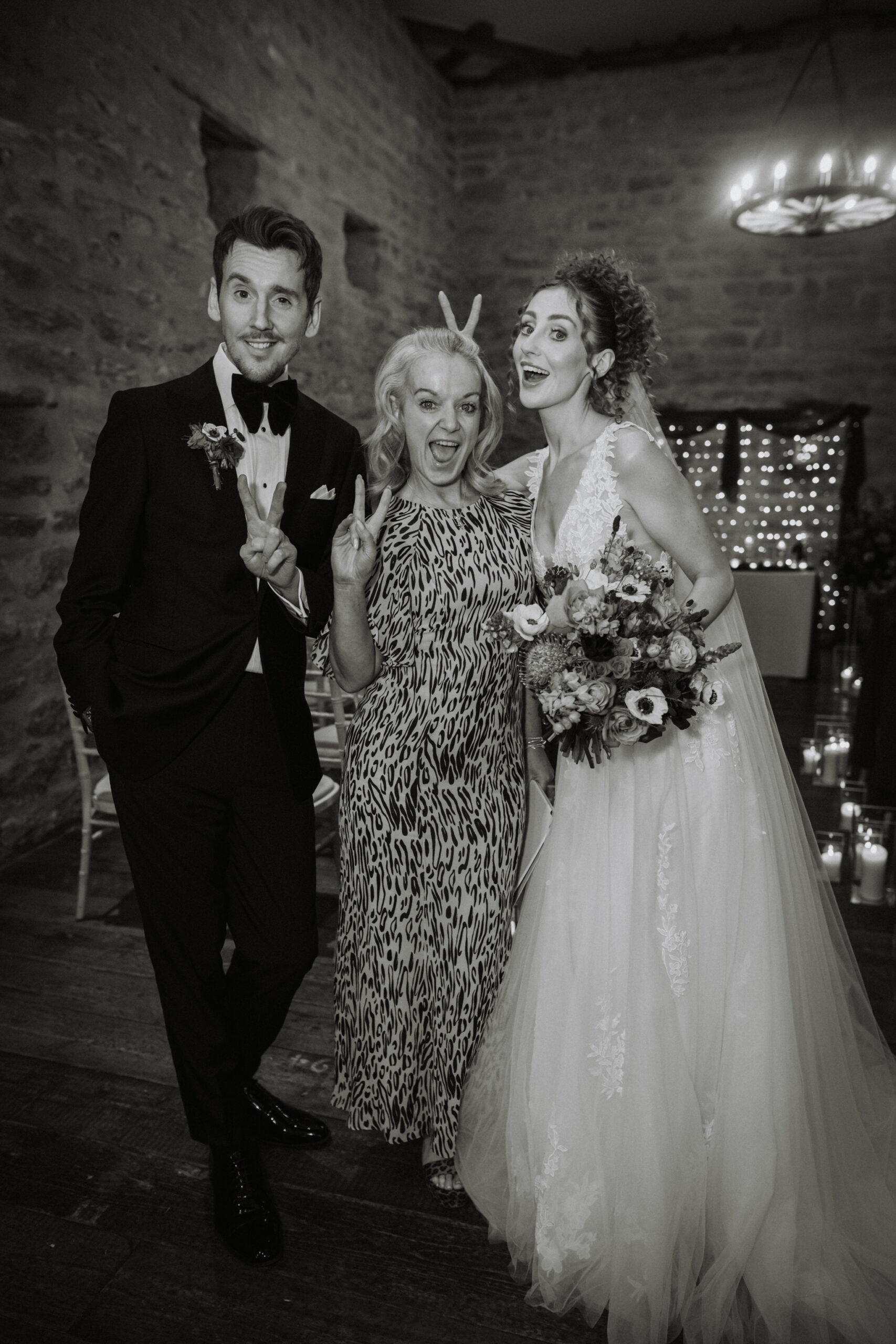 Gill, inclusive wedding celebrant in Lancashire and the North West, celebrating with a bride and groom in a quirky pose, all showing peace signs and smiling